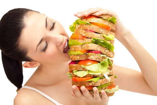 Woman is eating a huge sandwich