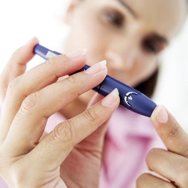 Woman checking her blood for diabetes